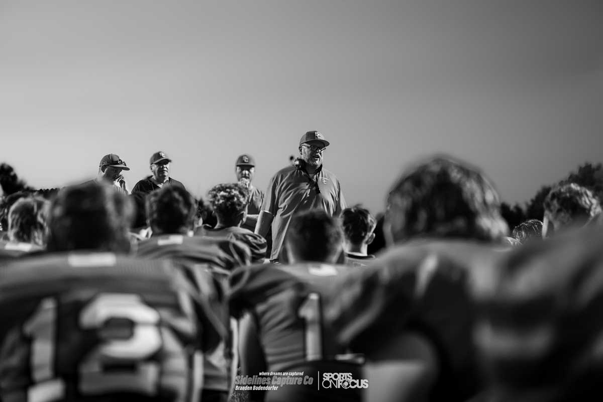 Spencer/Columbus head coach talking to his team in a postgame huddle, black and white